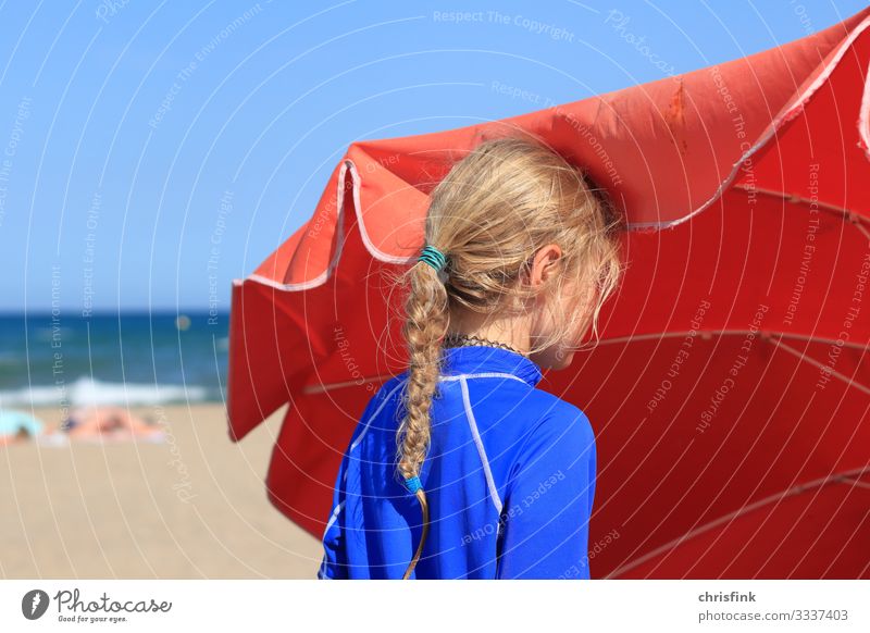 Girl standing on the beach next to a parasol Leisure and hobbies Vacation & Travel Tourism Summer Summer vacation Sun Beach Ocean Human being Child 1