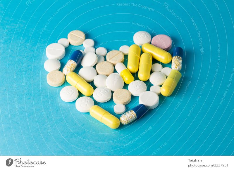 Medicines pills on blue background Sign Heart Relaxation Disappointment Healthy Health care Inspiration Pain Sex Sexuality Colour photo Studio shot Deserted