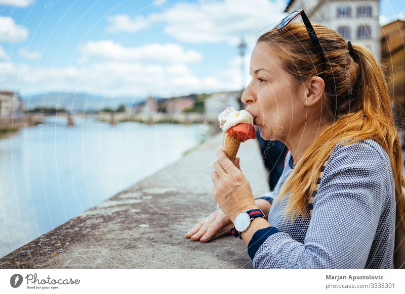 Young woman eating ice cream by the river in Florence Dessert Ice cream Fast food Lifestyle Vacation & Travel Tourism Trip Sightseeing City trip Human being