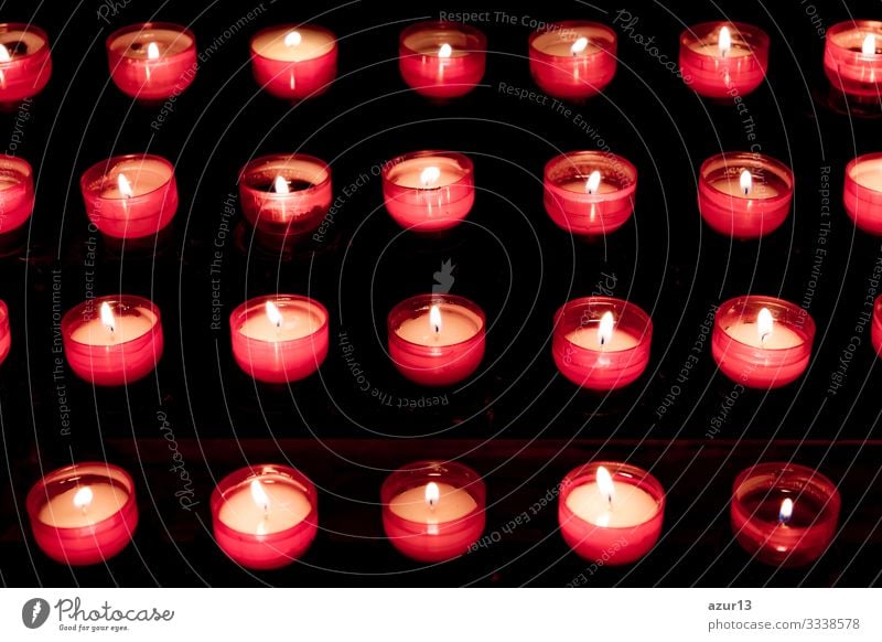 Group of red candles in church for faith resurrection prayer hope sacrifice silence grief love peace soul religion candlelight fire flames obituary obsequies