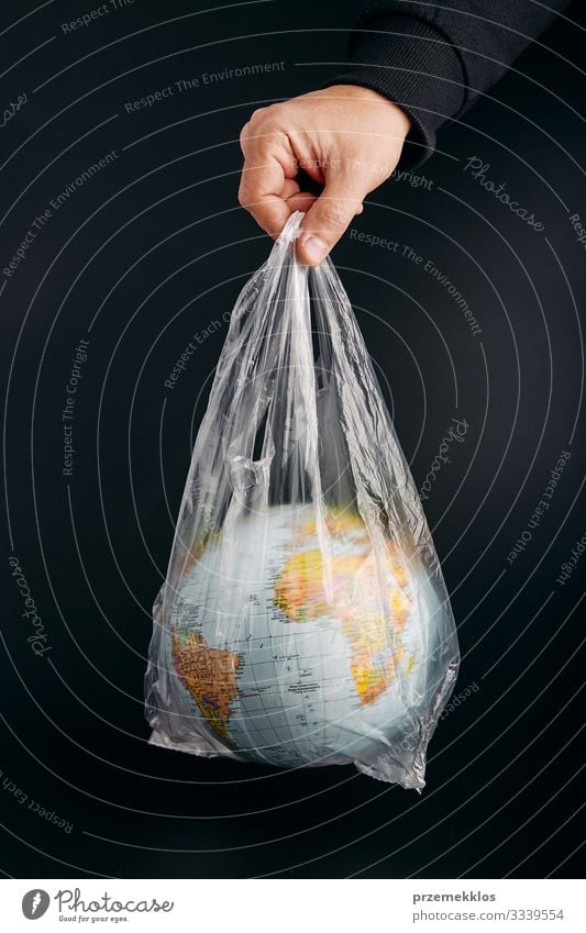 Male hand holding globe in a plastic bag. Contaminated Earth Save Life Man Adults Hand Environment Plastic Sphere Globe Green Black Environmental pollution