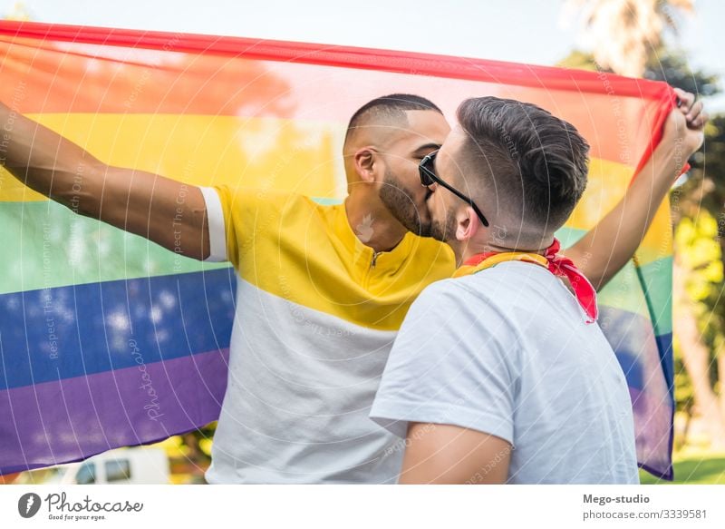 Gay couple kissing and showing their love with rainbow flag. Lifestyle Happy Freedom Feasts & Celebrations Human being Homosexual Man Adults Couple Partner 2
