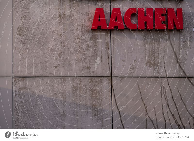 Aachen on the wall Town Downtown Building Wall (barrier) Wall (building) Facade Characters Signs and labeling Looking Esthetic Modern Red Authentic Design