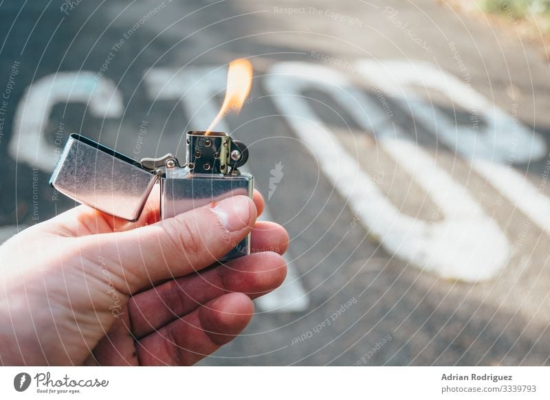 Lighter in hand lit with stop message in the background Man Adults Hand Power Protection Safety (feeling of) Dangerous Force Disaster Communication fire burn