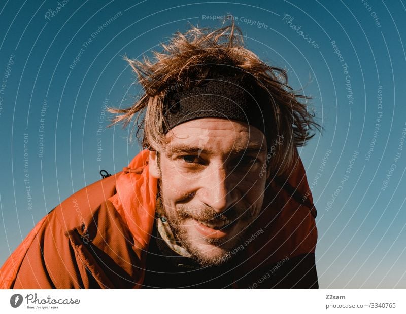 Portrait of a young hiker crusher tip sharpened Hiking Man Nature Peak portrait Athletic Face Facial hair Headband warm Sun Blue sky Landscape