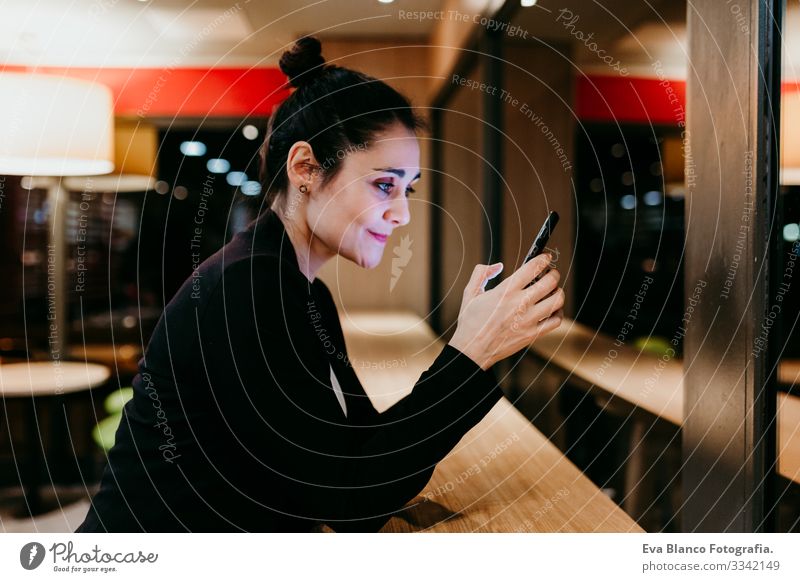 young woman using mobile phone in a cafe or restaurant indoors. Technology and lifestyle Woman Cellphone Interior shot Restaurant Café Window Businesswoman