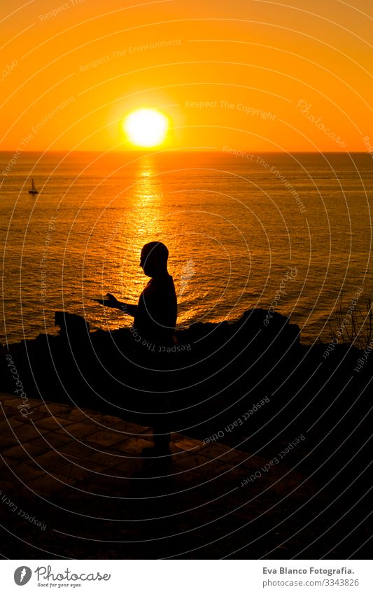 silhouette of a young man using mobile phone at sunset. Ocean background. Vacation and technology concept Youth (Young adults) Hand Solar cell Telephone