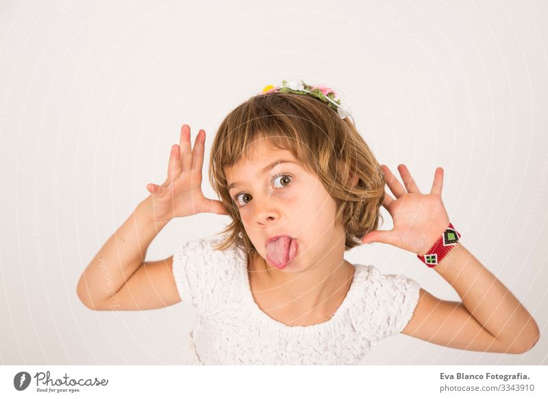 Little girl with funny face tongue outside on white background Portrait photograph Joy Child Cute lifestyle happiness Cheerful Beautiful Small Hair