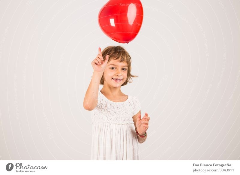 kid playing with a red balloon in the studio. Fun, lifestyle. white background Portrait photograph Joy Child Cute lifestyle happiness Cheerful Beautiful Small