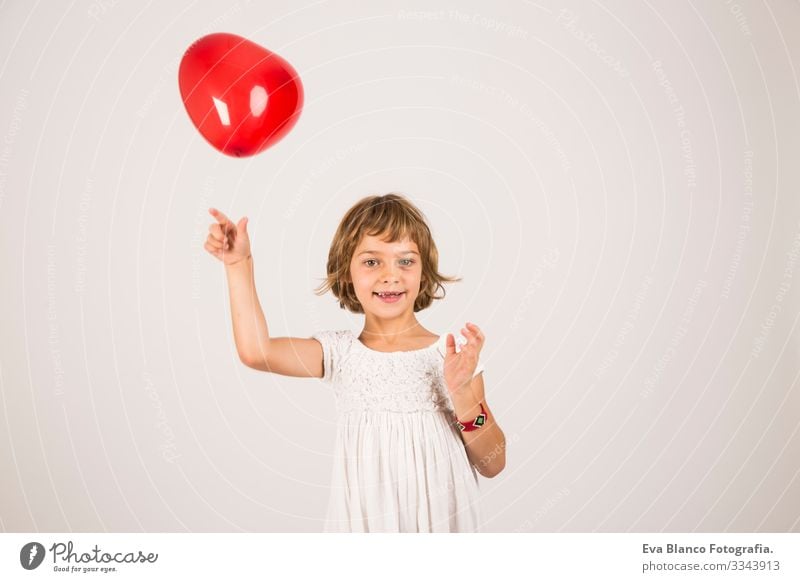 kid playing with a red balloon in the studio. Fun, lifestyle, white background Portrait photograph Joy Child Cute lifestyle happiness Cheerful Beautiful Small