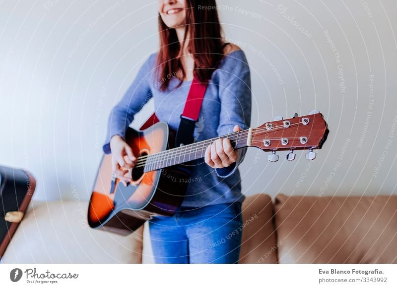 Young beautiful woman playing guitar standing on the sofa. Music concept Portrait photograph Drive Home Inspiration Bedroom Band Electric Rock Expression Guitar