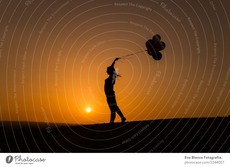 silhouette of a young woman playing with balloons at sunset Summer Sunset Love Joy Nature Silhouette Youth (Young adults) Woman Freedom Lifestyle Sky Relaxation