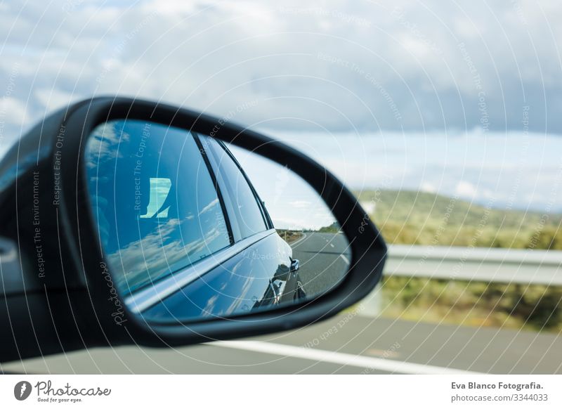 car on the road with motion blur background and rear view mirror. Travel concept. Cloudy sky Speed Blur Bright Mirror Street Modern Future Power Wheel Movement