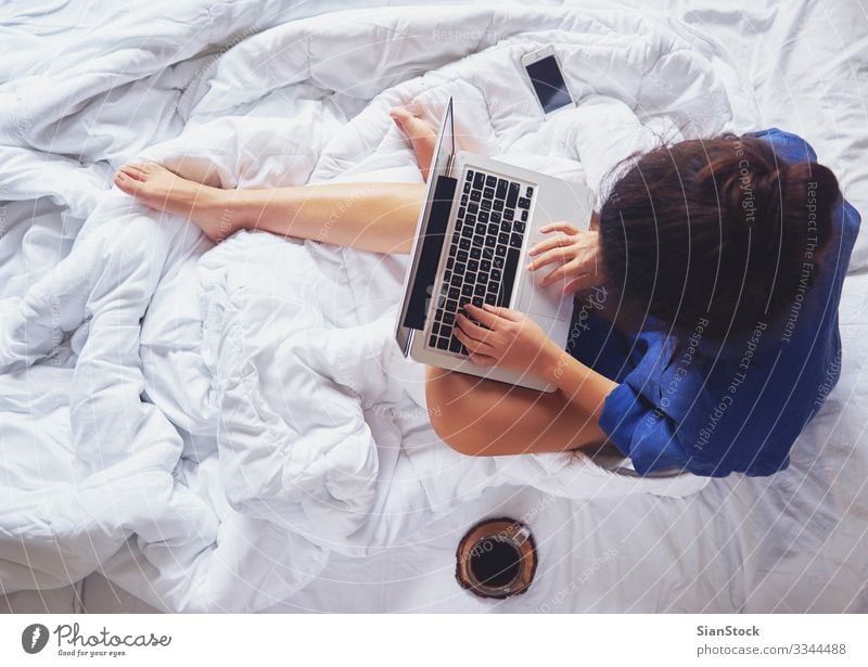 Young woman drinking coffee at home in her bed, top view Coffee Beautiful Life Relaxation Reading Bedroom Work and employment Workplace Computer Notebook Woman