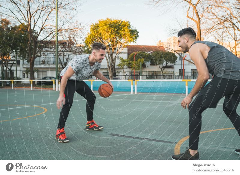 Two young friends playing basketball. Lifestyle Joy Happy Relaxation Leisure and hobbies Playing Sports Ball Human being Masculine Boy (child) Man Adults