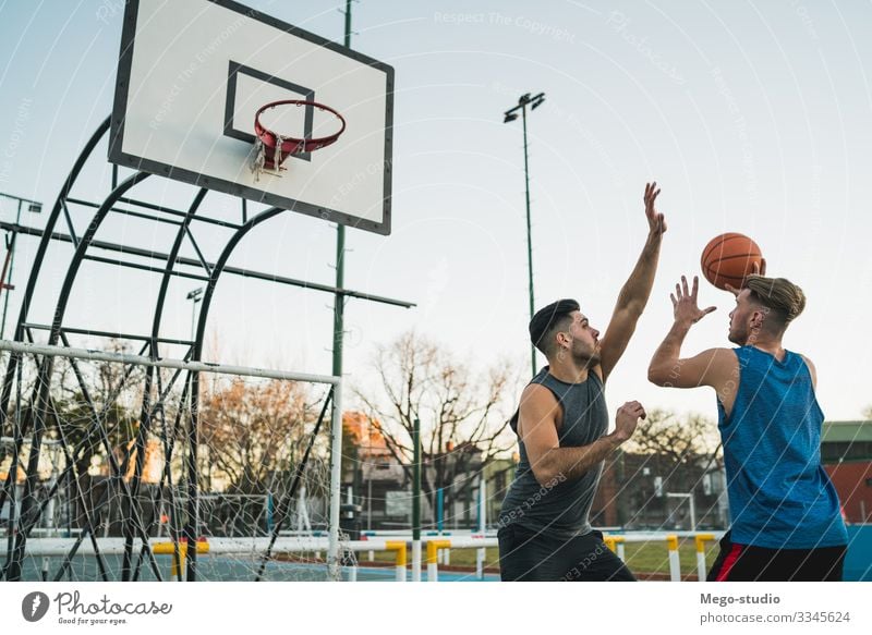 Young basketball players playing one-on-one on outdoor court. Joy Happy Relaxation Leisure and hobbies Playing Sports Ball Human being Masculine Boy (child) Man
