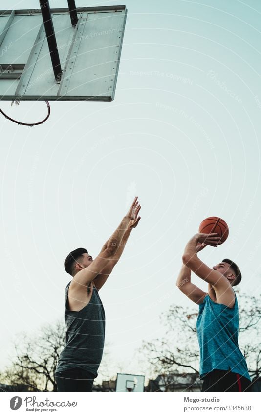 Young basketball players playing one-on-one. Joy Happy Relaxation Leisure and hobbies Playing Sports Ball Human being Masculine Boy (child) Man Adults