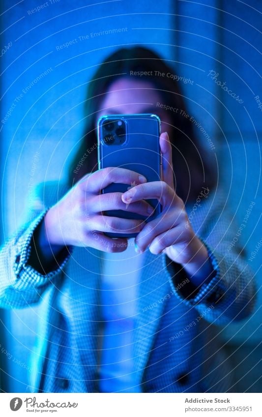 Contemporary faceless lady taking photo on smartphone woman shooting hands using mobile device gadget neon light female casual hipster millennial modern camera