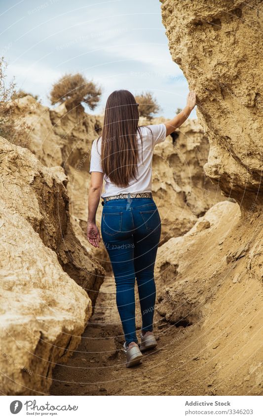 Anonymous female tourist exploring deserted terrain with cliffs travel canyon woman stone passage tourism activity extreme casual sky nature environment