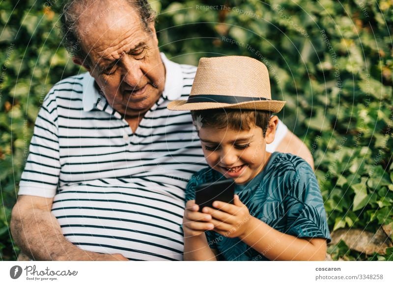 Grandfather and grandson playing with a mobile phone Lifestyle Happy Leisure and hobbies Playing Vacation & Travel Tourism Summer Summer vacation Child