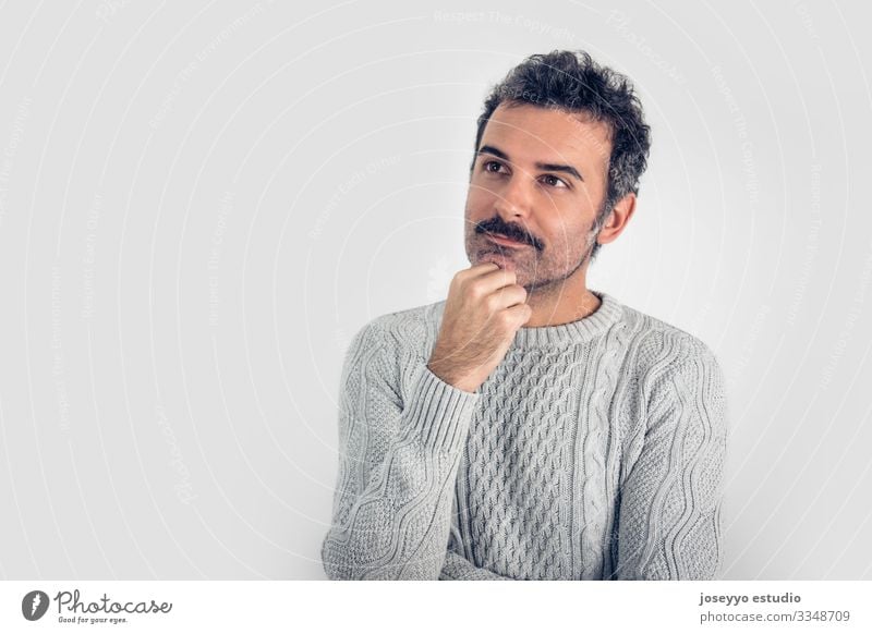 Portrait of  handsome and brown thinking man with mustache and  gray sweater. Gray background. Copy space adult arms attractive brain casual challenge