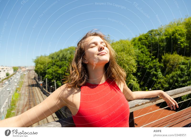 Young beautiful woman sunbathing on a bridge over the city Lifestyle Joy Happy Beautiful Relaxation Leisure and hobbies Summer Sun Sunbathing Woman Adults