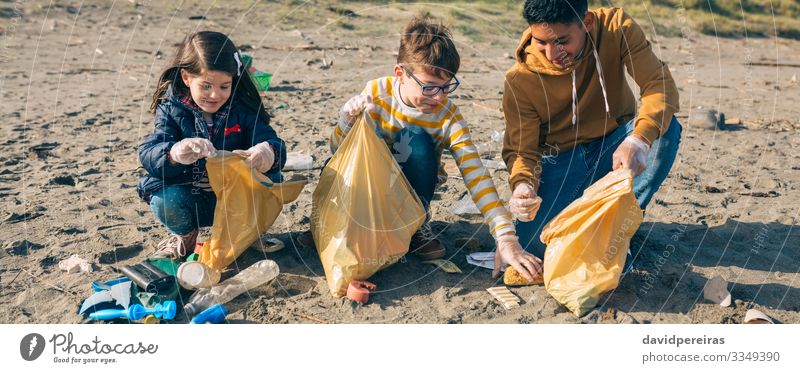Young volunteers picking up trash on the beach Happy Camping Beach Child Internet Human being Boy (child) Woman Adults Man Group Environment Sand Plastic