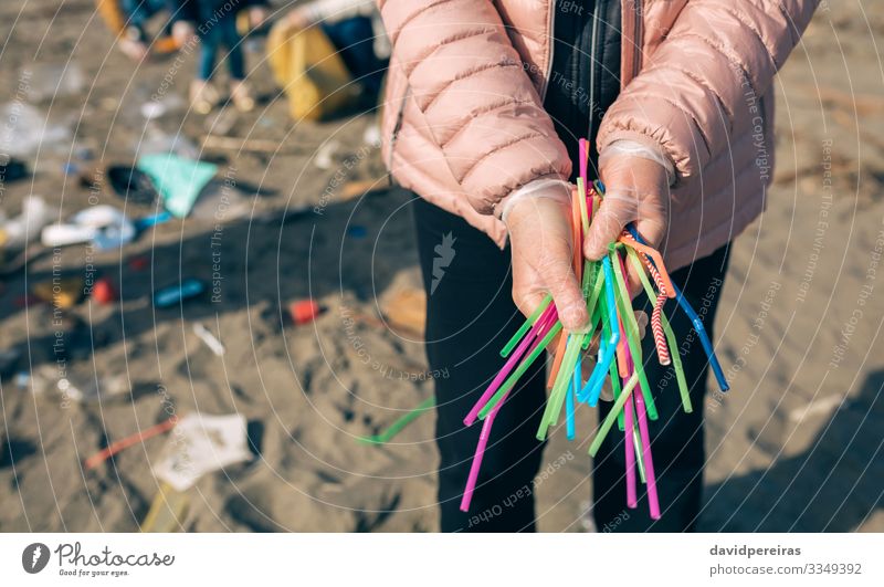 Woman showing handful of straws collected on the beach Straw Beach Work and employment Human being Adults Family & Relations Hand Group Environment Sand Plastic