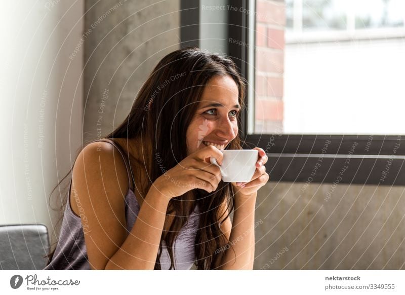 Young woman having a coffee break in office. Side view. Coffee Tea Work and employment Profession Workplace Office Woman Adults Youth (Young adults) Smiling Sit