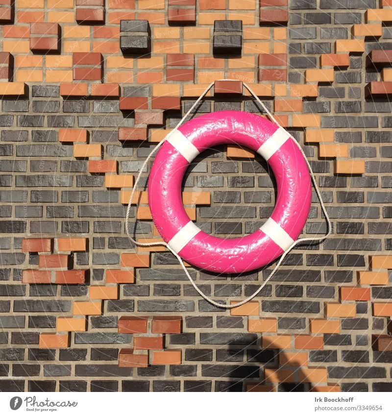 colourful lifebelt in the port of Hamburg Trip Port City Deserted Manmade structures Wall (barrier) Wall (building) Sign Life belt Hang Maritime Pink Trust