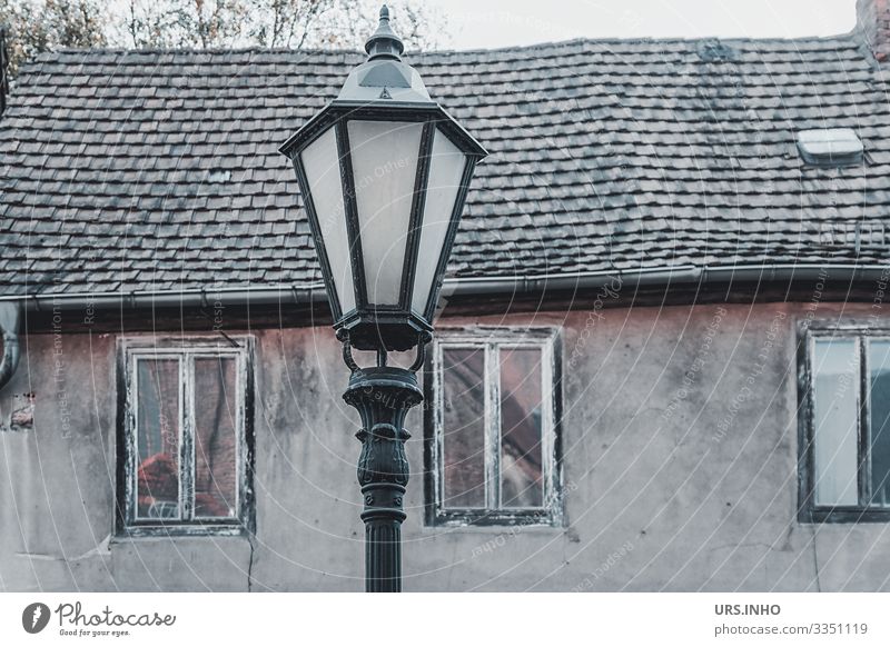 Streetlight in front of an old house Village Deserted Building Wall (barrier) Wall (building) Facade Window Roof Old Poverty Hideous Retro Brown Gray Black