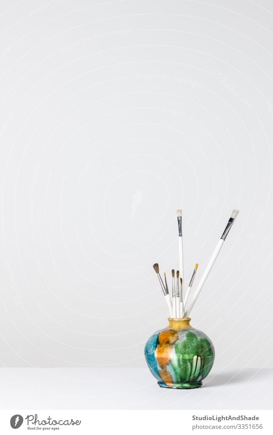 Paintbrushes in a colorful ceramic vase Design Interior design Decoration Desk Table Craft (trade) Art Simple Bright Modern Gray Green White Colour Creativity