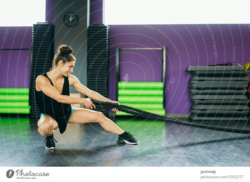 Young and athletic woman using training ropes in a gym. Lifestyle Personal hygiene Body Wellness Club Disco Sports Rope Human being Feminine Young woman