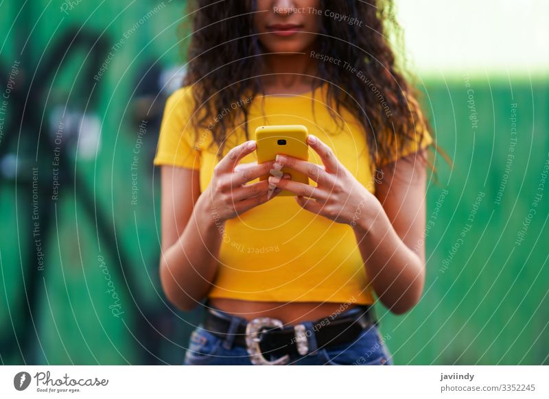 Young Arab woman walking in the street using her smartphone Lifestyle Style Happy Beautiful Hair and hairstyles Face Telephone PDA Technology Human being