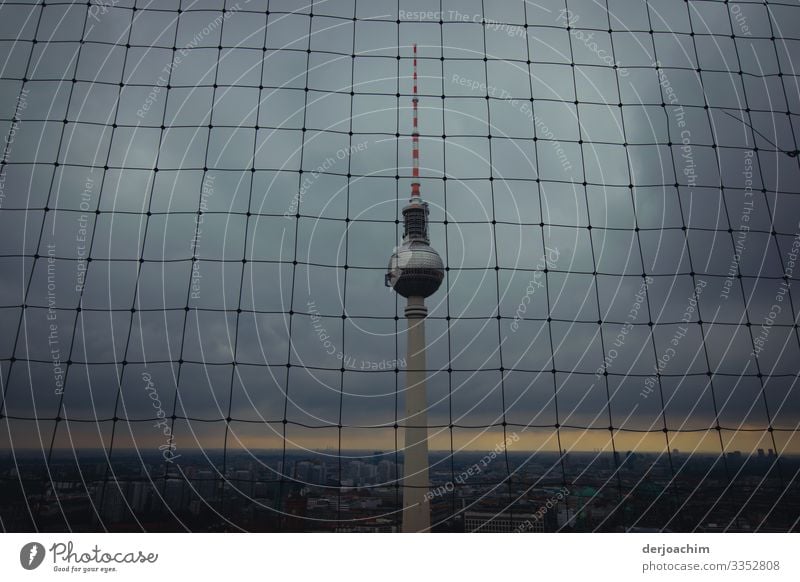 Bad weather at the Berlin TV tower tower. The tower is behind a grid. The background is dark. Design Life Telecommunications Environment Summer Downtown