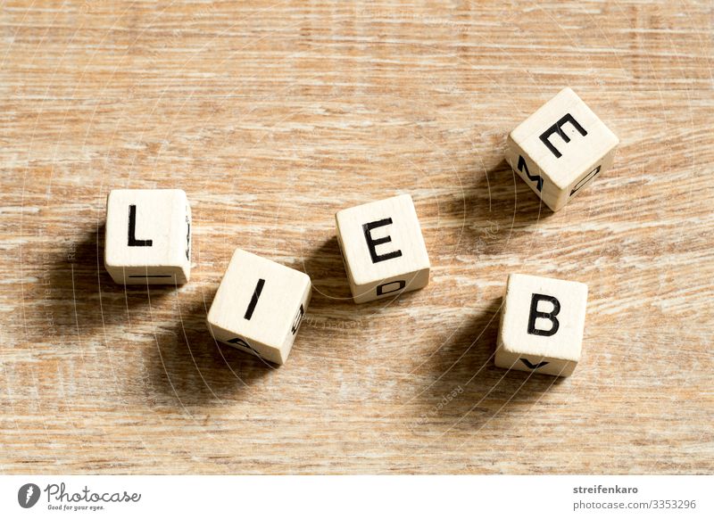 Wooden cubes with letters form the lettering LIEBE on a wooden background Joy Happy Couple Partner Life Cube Characters Love Emotions Joie de vivre (Vitality)