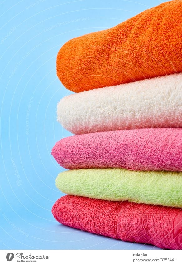 Stack of bath towels on wooden background. White and pink cotton