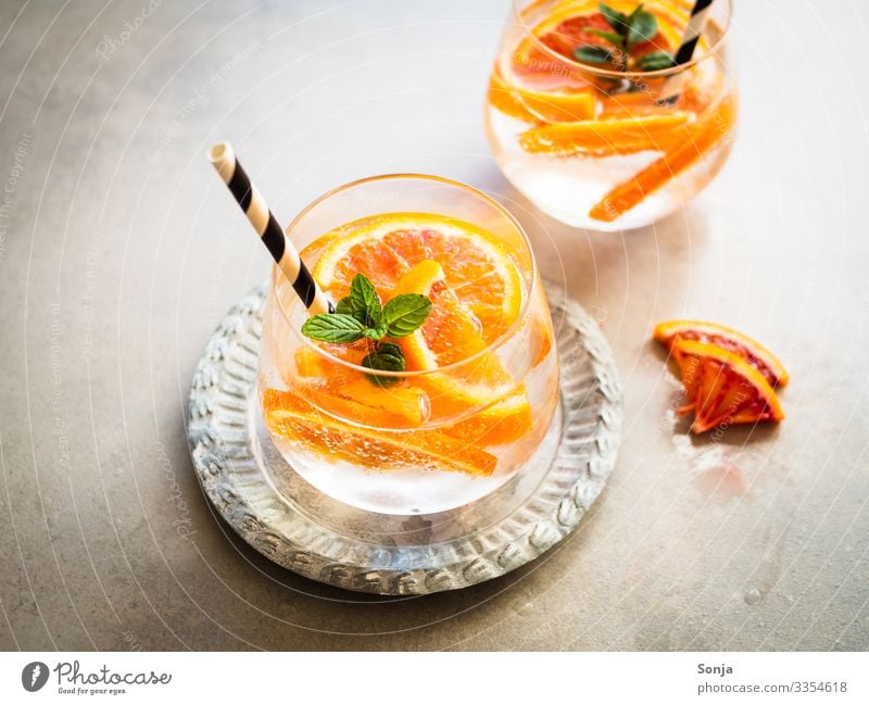 Cocktail with fresh oranges and peppermint in one glass Orange Herbs and spices Mint Diet Beverage Drinking water Lemonade Juice Longdrink Plate Glass Straw