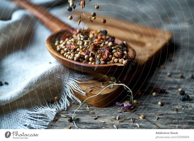 Dry mix of spices and dried berries in spoon on table fragrant herb harvest ripe natural pepper seasoning healthy edible wooden gathering heap ingredient