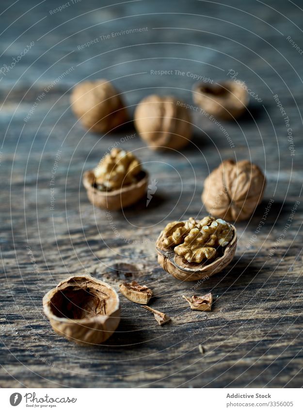 Ripe half peeled walnuts at wooden table ripe healthy edible filbert harvest gathering heap ingredient natural organic raw cracked seed food snack tasty