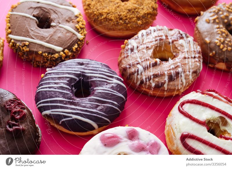 Variety of doughnuts on pink background variety assortment sweet icing glazed food donut sugar bakery pastry sprinkle fried colorful many dessert delicious