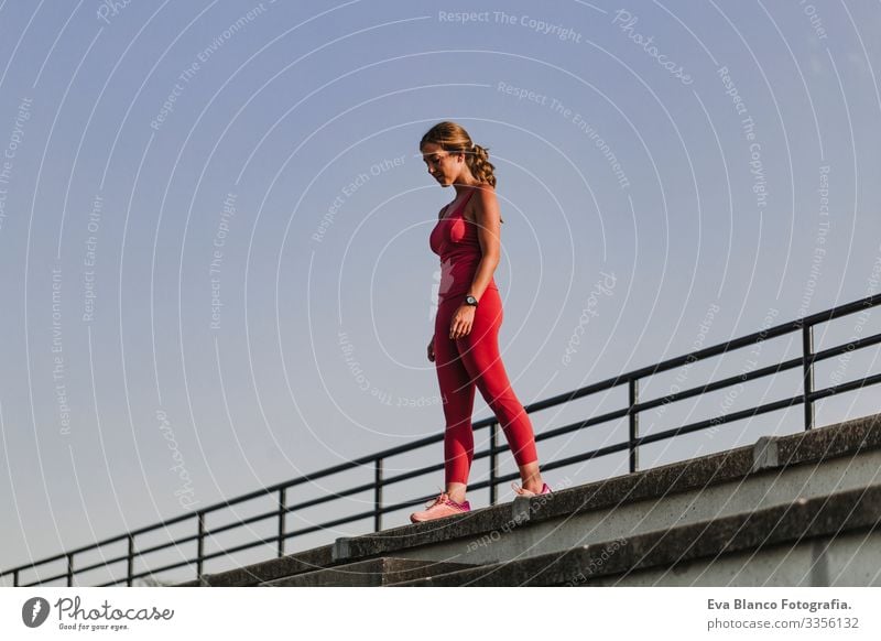 Fitness woman on stadium ready to practice sport. Wearing Red sport clothes. healthy lifestyle concept. Sunset at summer Body Woman Stadium Wellness Athlete