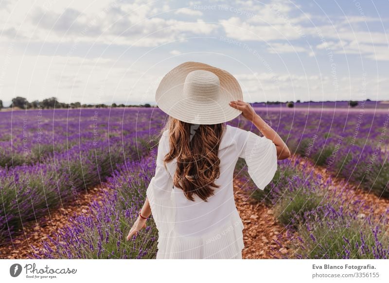 charming Young woman with a hat and white dress in a purple lavender field at sunset. LIfestyle outdoors. Back view Sunset Meadow Beauty Photography Joy