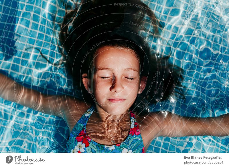 beautiful teenager girl floating in a pool and looking at the camera. Fun and summer lifestyle Action Swimming pool Beauty Photography Exterior shot