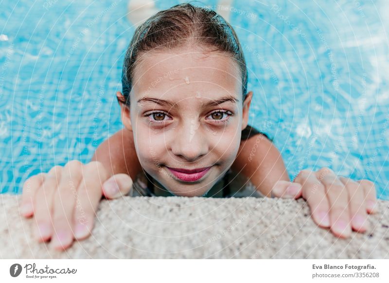 beautiful teenager girl floating in a pool and looking at the camera. Fun and summer lifestyle Action Swimming pool Beauty Photography Exterior shot