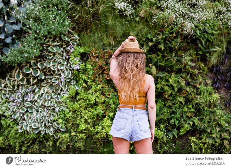 portrait of a young blonde beautiful woman at the street smiling. Green vegetation background. Lifestyle outdoors. Summertime Modern Hip & trendy Eroticism