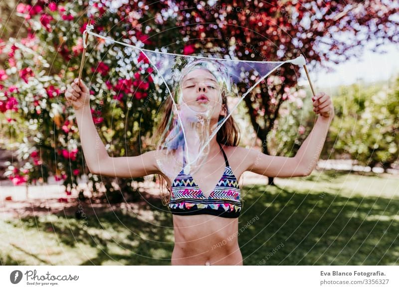 cute kid girl playing outdoors with bubbles, summertime Lifestyle Swimming pool Vacation & Travel Sun Summer healthy Caucasian Smiling Blue enjoyment Swimwear
