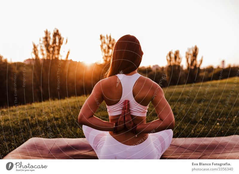 young beautiful asian woman doing yoga in a park at sunset. Yoga and healthy lifestyle concept. Back view Youth (Young adults) Woman Summer Happy enjoyment