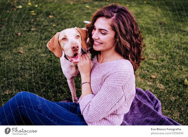 young woman with her dog at the park. she is hugging the dog. autumn season Portrait photograph Woman Dog Park Youth (Young adults) Exterior shot Love Pet owner