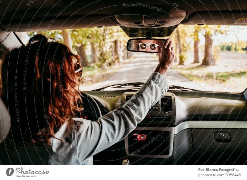 young beautiful woman driving a car. travel concept. view from inside. path of trees road Woman Youth (Young adults) Driving Car Sunbeam Sunglasses